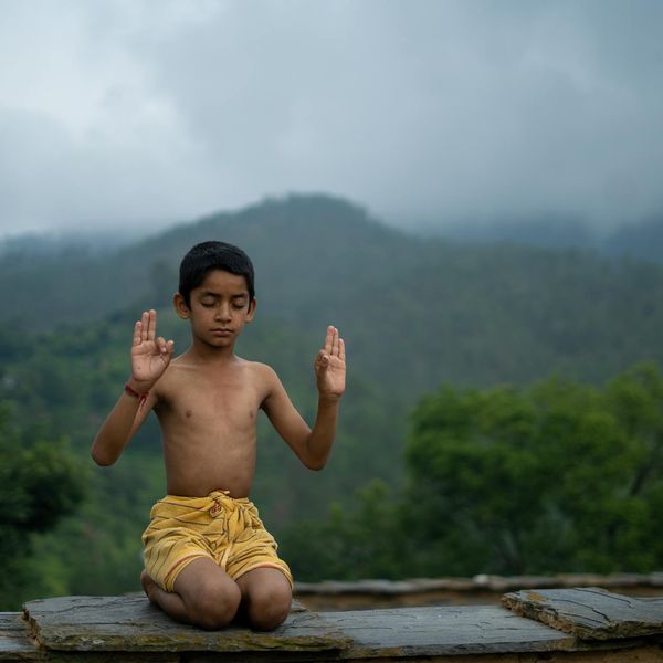 A serene person meditating outdoors with a peaceful landscape in the background.