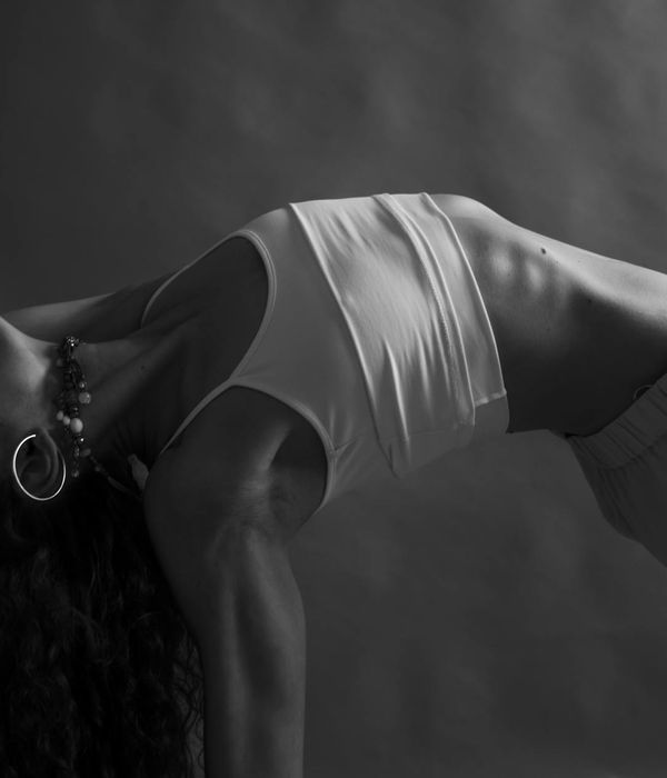 Woman performing a graceful yoga pose in a calm, focused environment.